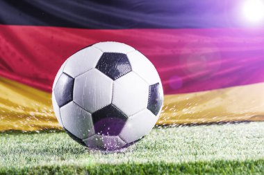 Alman bayrağı ve futbol topunun çimen futbol sahasında yakın plan görüntüsü