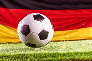 Alman bayrağı ve futbol topunun çimen futbol sahasında yakın plan görüntüsü