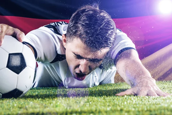 emotional young soccer player reaching for ball on green grass of stadium