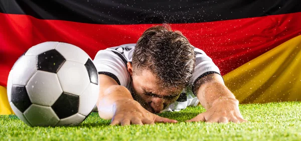 emotional young soccer player reaching for ball on green grass of stadium