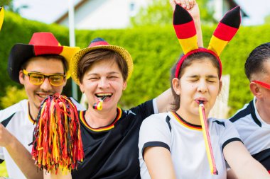 Aile bahçede Alman futbol takımı için tezahürat yapıyor.