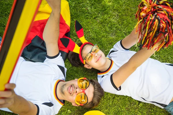 Χαρούμενοι Οπαδοί Του Ποδοσφαίρου Από Γερμανία Ξαπλωμένοι Ένα Λιβάδι Γιορτάζοντας — Φωτογραφία Αρχείου