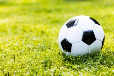 Yeşil çimlerin üzerinde futbol topunun yakın plan görüntüsü