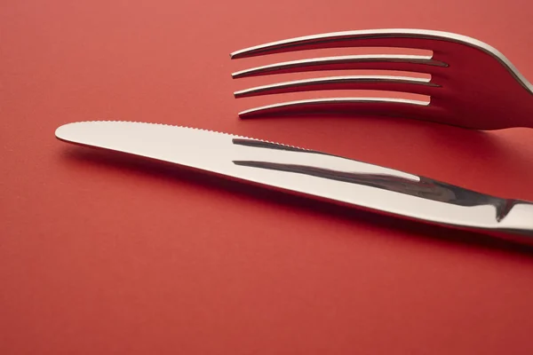 Dettaglio coltello e forchetta su fondo rosso. Posate — Foto Stock