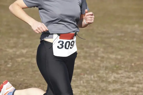 Vrouwelijke atletische loper op een langlauf-race. Openlucht circuit — Stockfoto