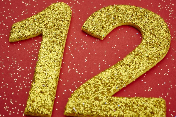Número doce de color amarillo sobre fondo rojo. Aniversario — Foto de Stock