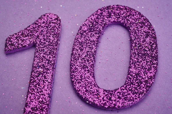 Numero dieci colore viola su uno sfondo viola. Anniversario — Foto Stock