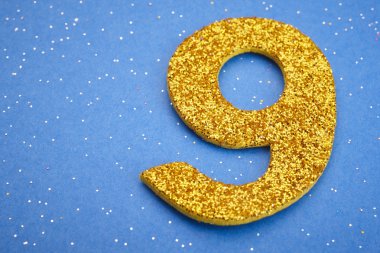 Dokuz sarı renk mavi bir arka plan üzerinde numara. Yıldönümü