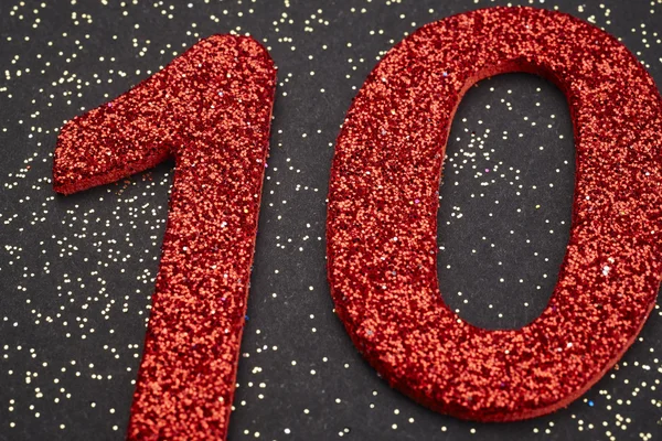 Número diez de color rojo sobre fondo negro. Aniversario — Foto de Stock