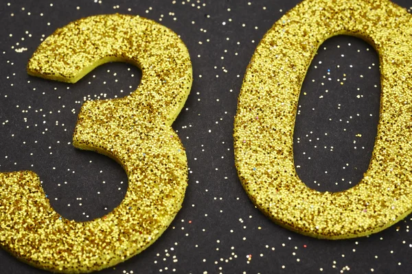 Number thirty yellow color over a black background. Anniversary — Stock Photo, Image