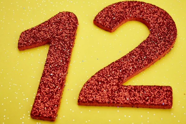 Nummer twaalf rode kleur op een gele achtergrond. Verjaardag — Stockfoto