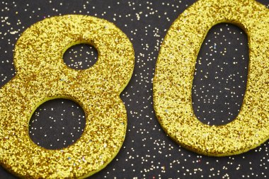 Seksen altın rengi siyah bir arka plan üzerinde numara. Yıldönümü