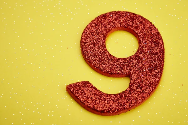 Number nine red color over a yellow background. Anniversary. — Stock Photo, Image