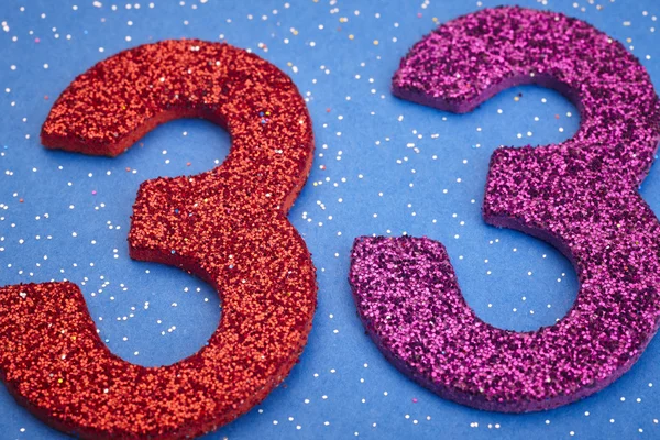 Number thirtythree red purple color over a blue background. Anni — Stock Photo, Image