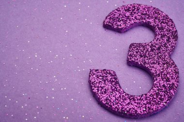 Üç mor renk mor bir arka plan üzerinde numara. Yıldönümü