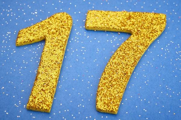 Number seventeen yellow color over a blue background. Anniversar — Stock Photo, Image