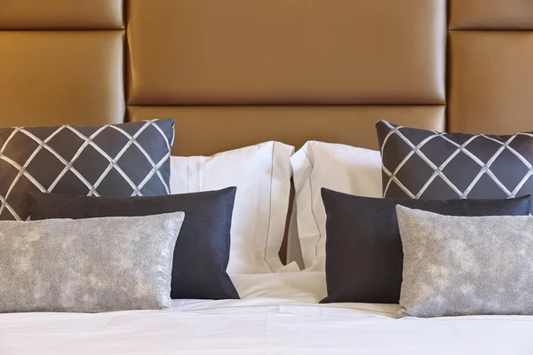 Kahverengi deri yatak baş detay yastıkları ile 