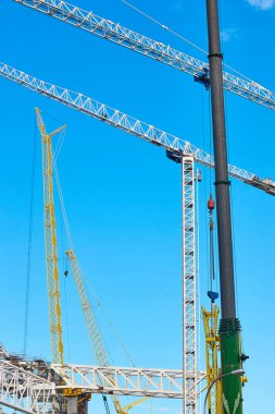 Mavi gökyüzünün altında teleskopik vinçler. İnşaat mühendisliği endüstrisi
