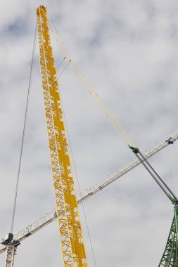 Teleskopik vinçler beyaz gökyüzünün altında. İnşaat mühendisliği endüstrisi