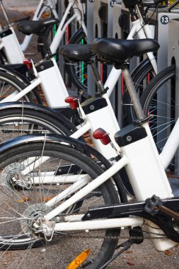 Şehirdeki elektrikli bisikletlerin pilleri şarj ediliyor. Kiralık.