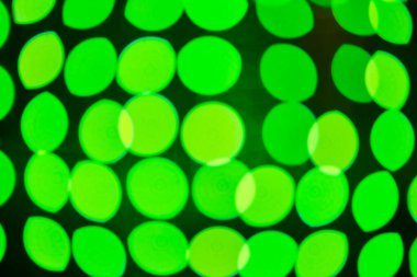 Şehir gecesinde odak dışı yeşil ışıklar. Renkli arkaplan