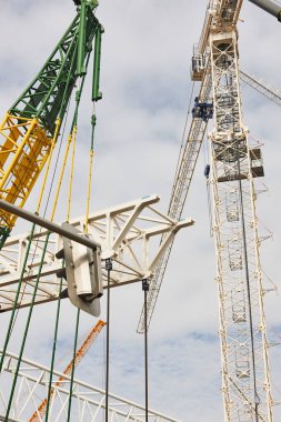Teleskopik vinçler beyaz gökyüzünün altında. İnşaat mühendisliği endüstrisi
