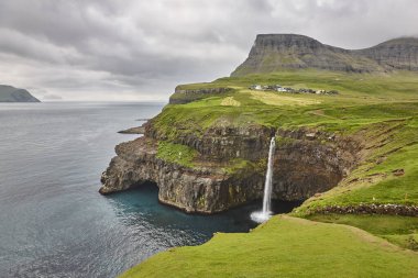 Şelale ve Vagar 'daki kayalıklar. Faroe Adaları dramatik kıyı şeridi. Gasaladur