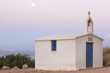 Yunan kilisesi ile dolunay gün batımında. Girit
