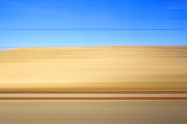 Vue paysage jaune et bleu depuis un train — Photo