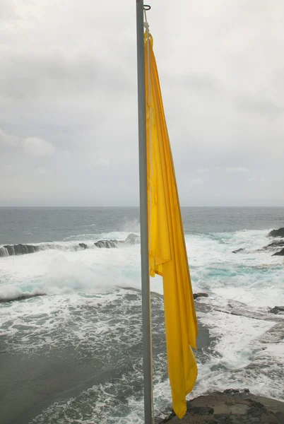 Желтый флаг на побережье — стоковое фото