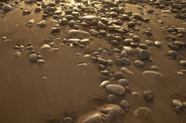 Areia e pedras na praia em tom quente — Fotografia de Stock