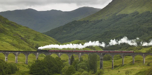 Шотландский паровоз, проходящий через классический мост — стоковое фото