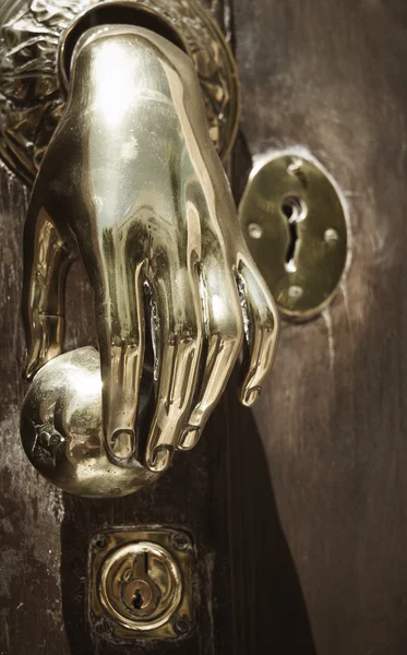 Золотая дверная ручка на деревянной двери в Испании — стоковое фото