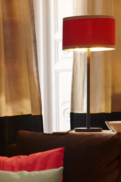 Интерьер дома с красной лампой и окно с занавесками — стоковое фото