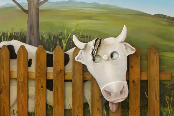 Figura vaca con valla de madera y fondo verde —  Fotos de Stock