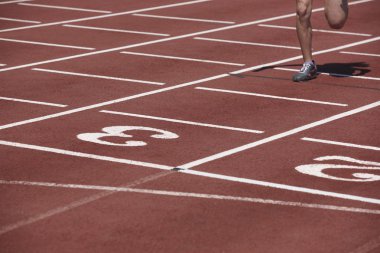 Male runner finalizing a race in a running track