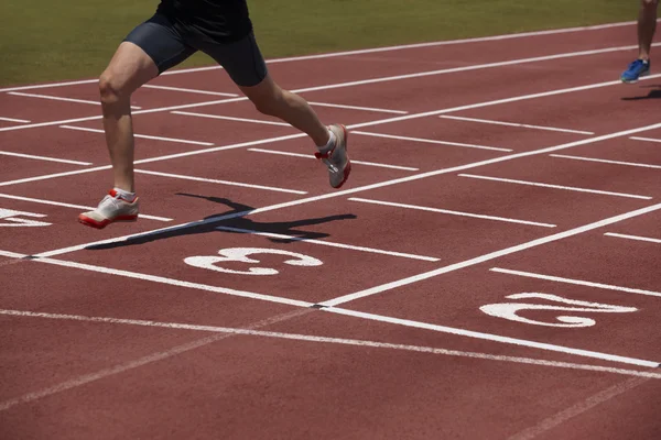 Detalhe de um atleta masculino em uma pista de corrida — Fotografia de Stock