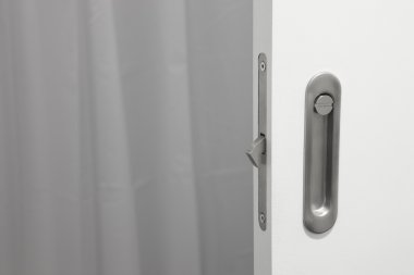 Kilit üzerinde beyaz bir kapı ile banyo metalik kapı kolu