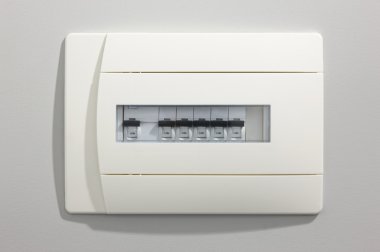 Dokulu bir duvarın üzerinden elektrik anahtarları beyaz tahta