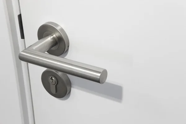 Metalowe klamki z blokadą nad białe drzwi — Zdjęcie stockowe