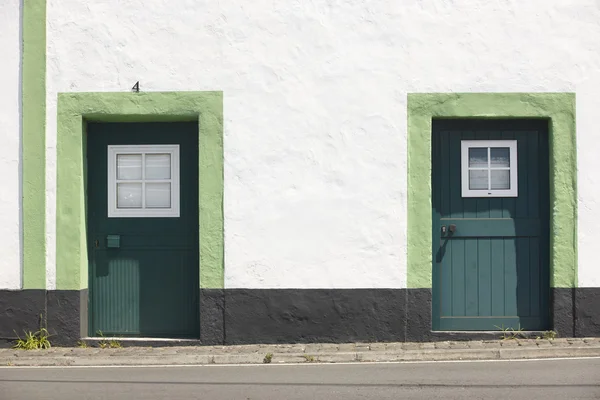 Green doors over a white facade building and street. Azores — Stock Photo, Image