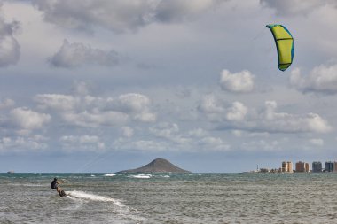 Olgun bir adam uçurtma uçurma alıştırması yapıyor. Sucul sporu. Atletik sağlıklı son sınıf öğrencisi.