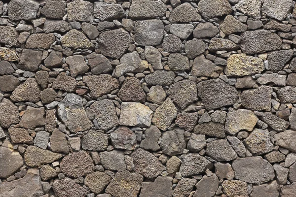 Basalt vulkanisk sten bakgrund fasad i varm ton — Stockfoto
