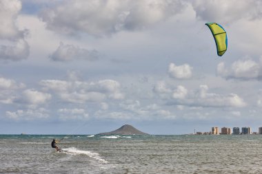 Olgun bir adam uçurtma uçurma alıştırması yapıyor. Sucul sporu. Atletik sağlıklı son sınıf öğrencisi.