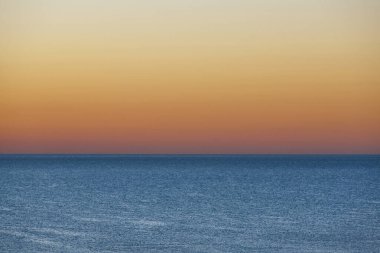 Deniz kenarında gün doğumu. Alacakaranlıkta ufuk çizgisi. Deniz Burnu