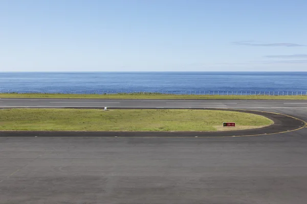 Piste de l'aéroport près de l'océan avec lignes et clôture — Photo