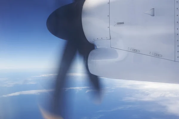 Aeroplane flying over the ocean and turbine detail in movement — Stock Photo, Image