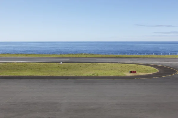 Start-en landingsbaan luchthaven dicht bij de oceaan met lijnen en hek — Stockfoto
