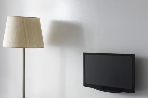 Quarto de hotel interior com lâmpada e tv na parede — Fotografia de Stock