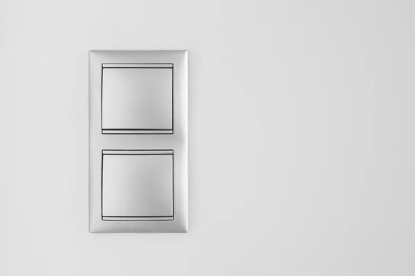 Podwójne metalowe włącznik światła na białej ścianie. Miejsce — Zdjęcie stockowe